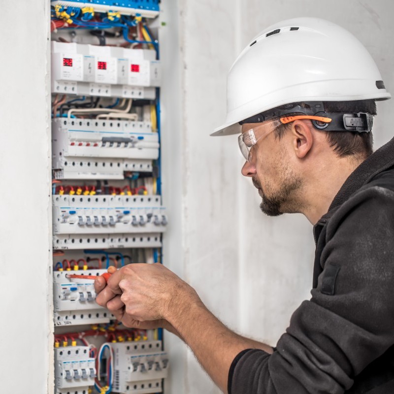 Un électricien travaille sur un tableau électrique